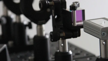 Ein optisches Experiment, bestehend aus Laser, Strahlteiler und Polarisationsfilter