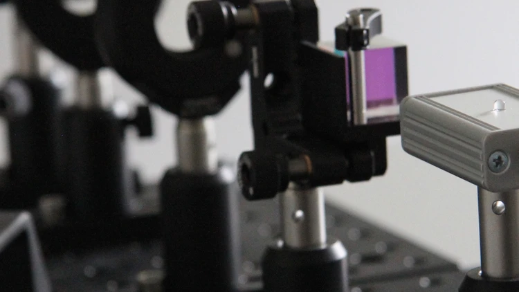 Ein optisches Experiment, bestehend aus Laser, Strahlteiler und Polarisationsfilter